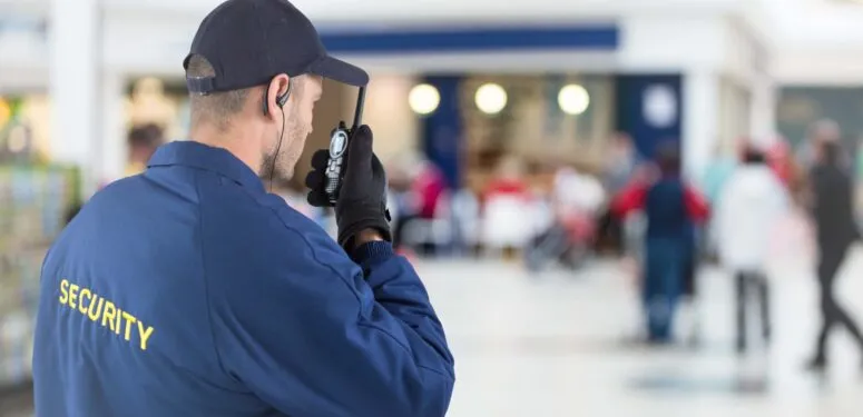 retail security guard speaking into two way radio